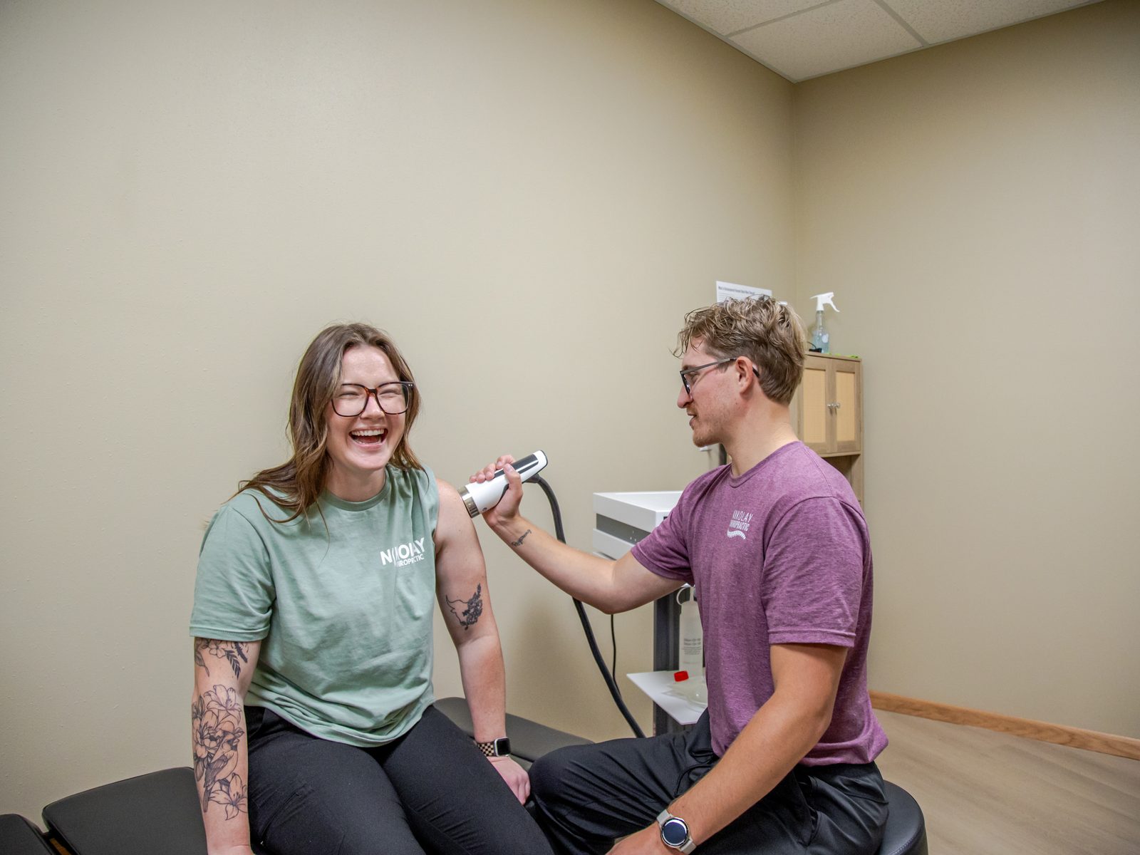 Dr. Matt performing shockwave therapy on a smiling patient